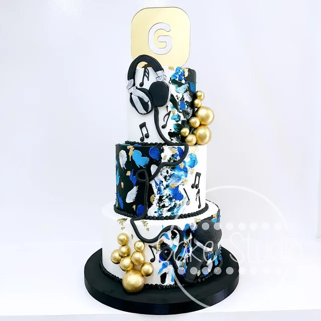 Pastel corporativo de tres niveles en azul, negro y blanco con audífonos, notas musicales y número 6, de Cake Studio